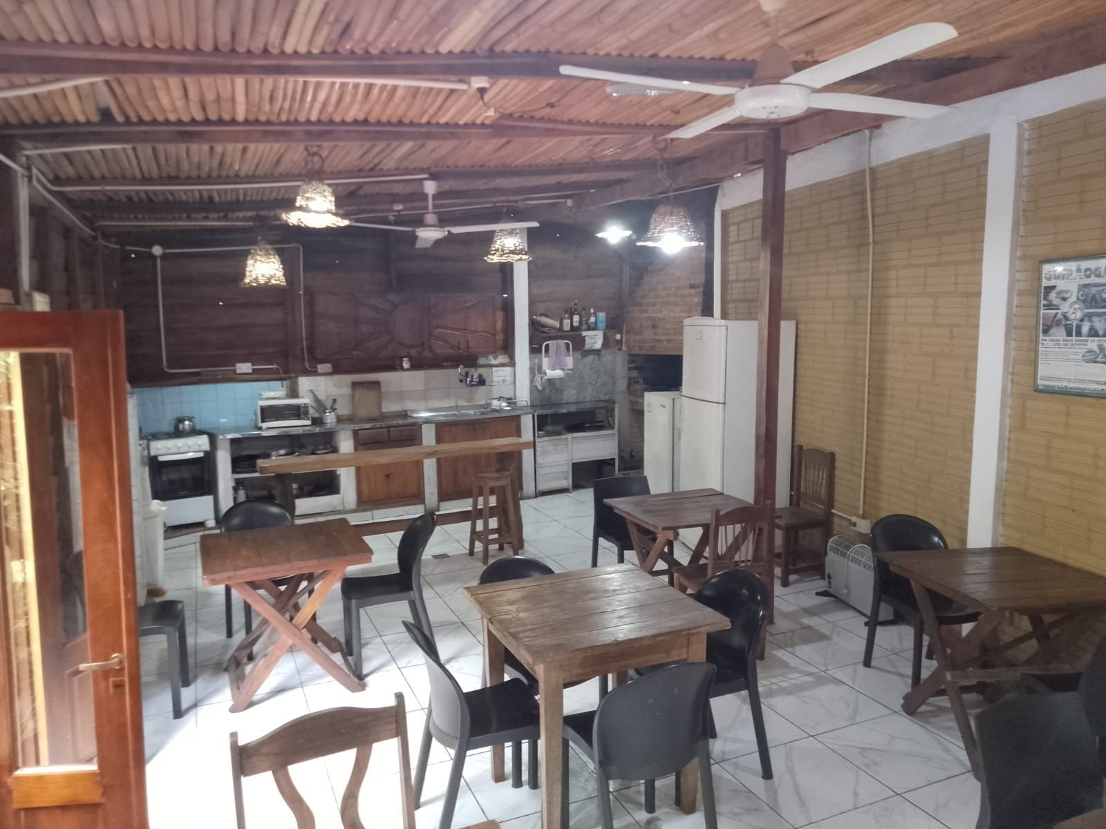 Una habitación con mesas y sillas y un ventilador de techo.