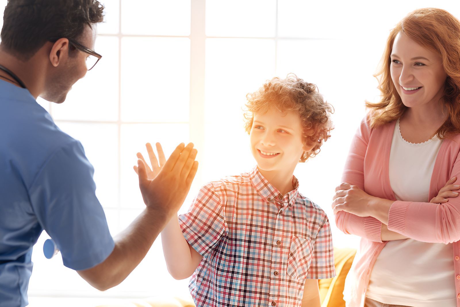 A Doctor is Giving a High Five to a Boy — Newcastle Paediatric Occupational Therapy in Belmont, NSW
