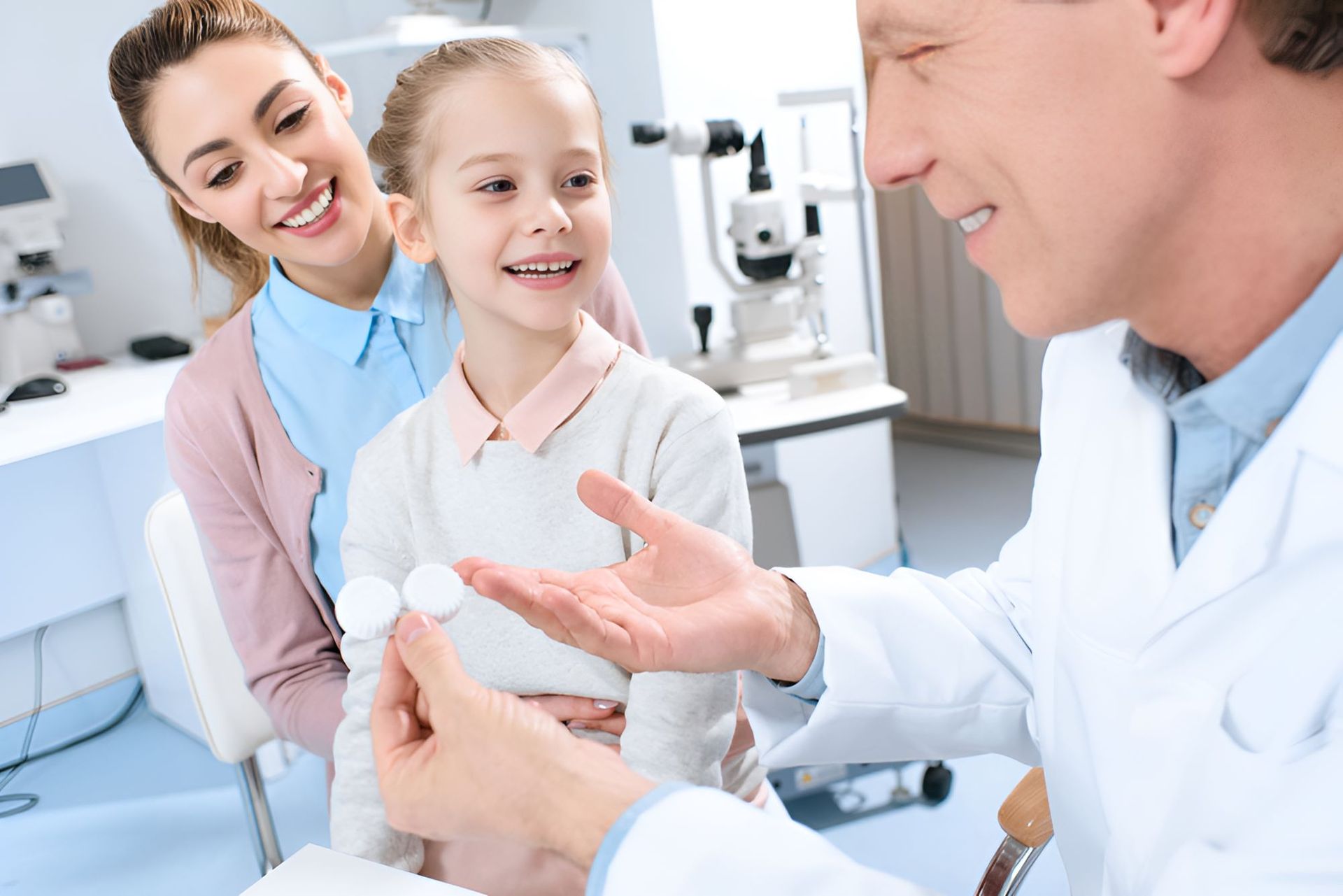 A Doctor is Giving a Little Girl a Pair of Contact Lenses — Newcastle Paediatric Occupational Therapy in Broadmeadow, NSW