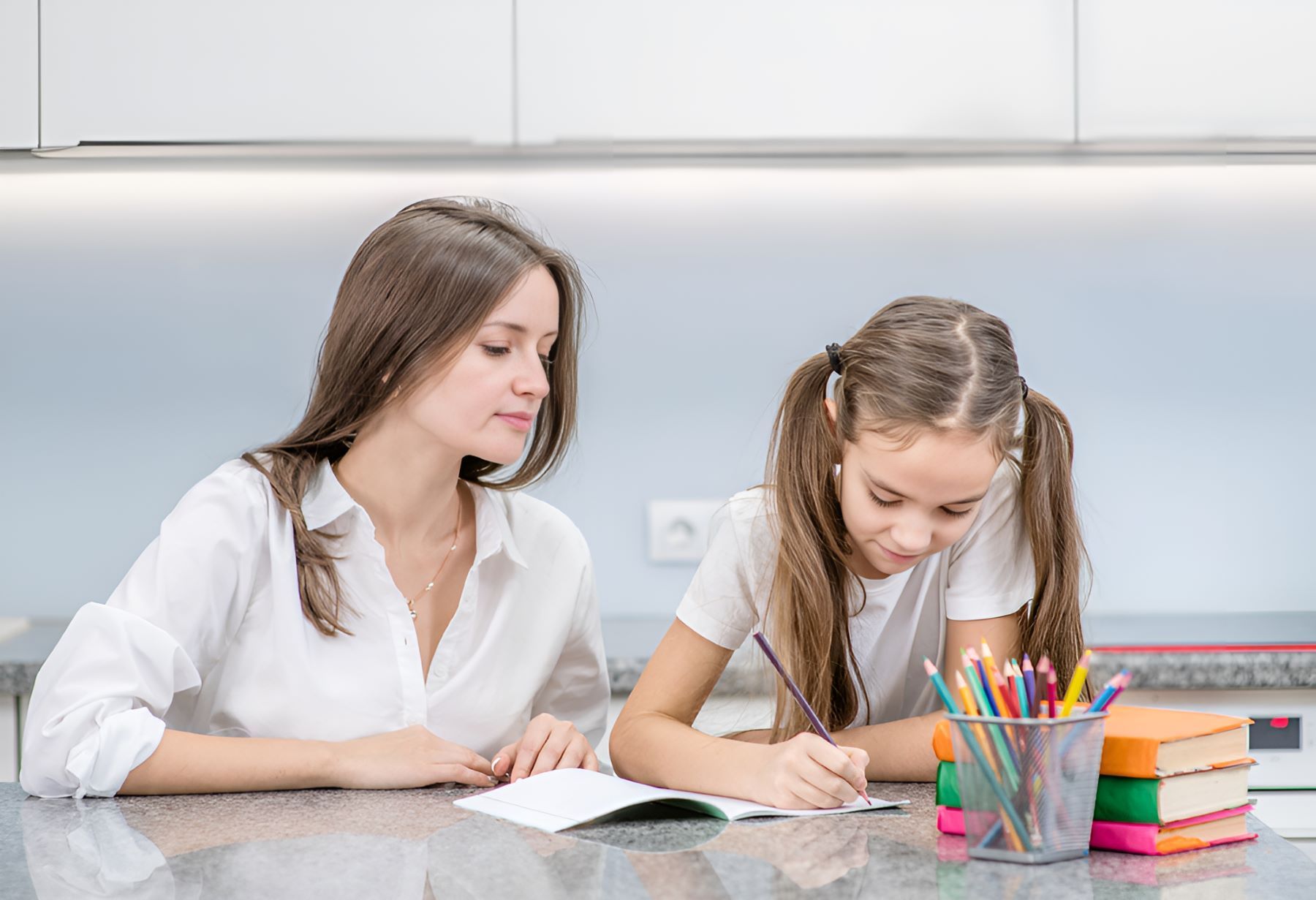 A Woman is Helping a Little Girl With Her Homework