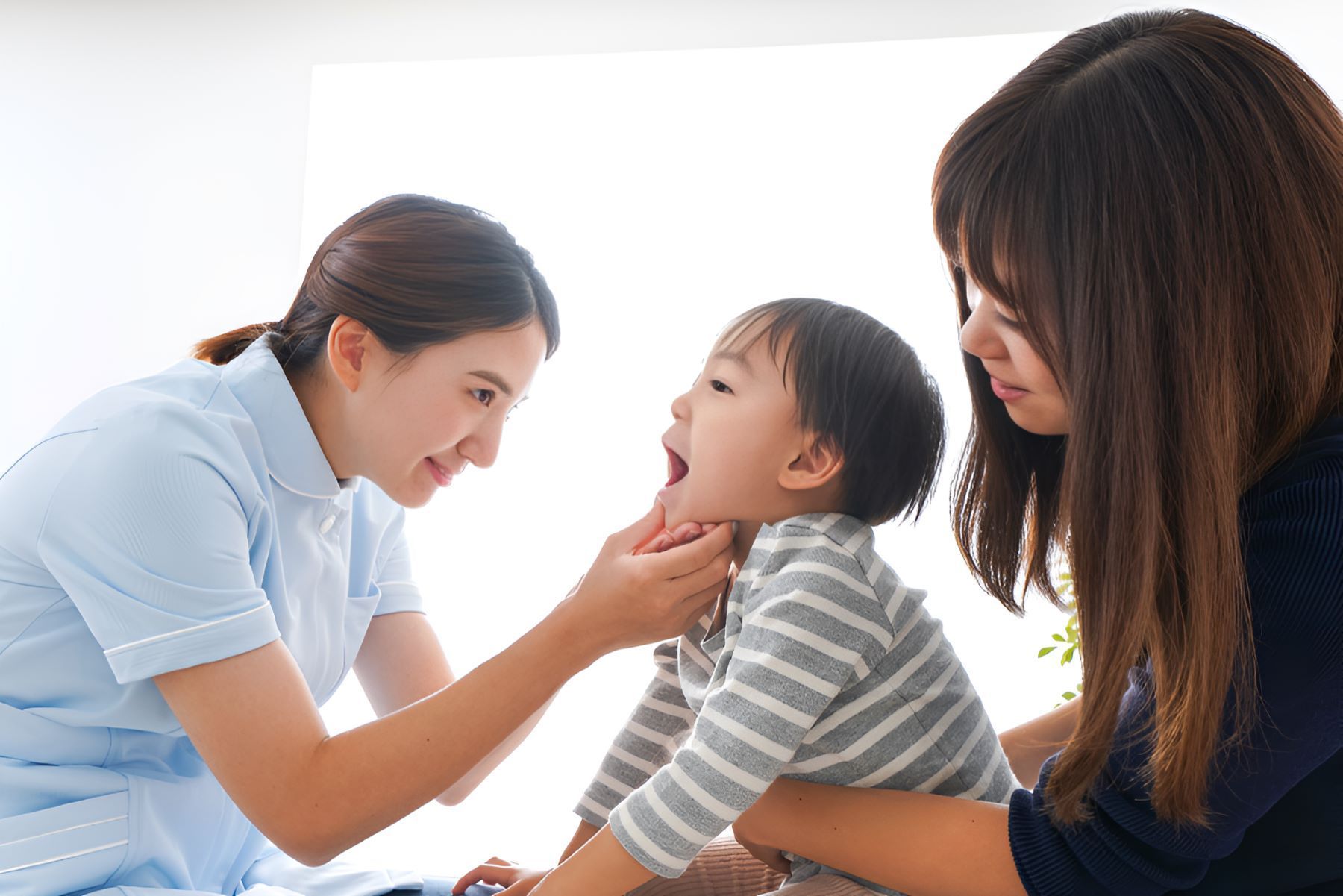 A Woman is Holding a Baby While Another Woman Looks on — Newcastle Paediatric Occupational Therapy in Lake Macquarie, NSW