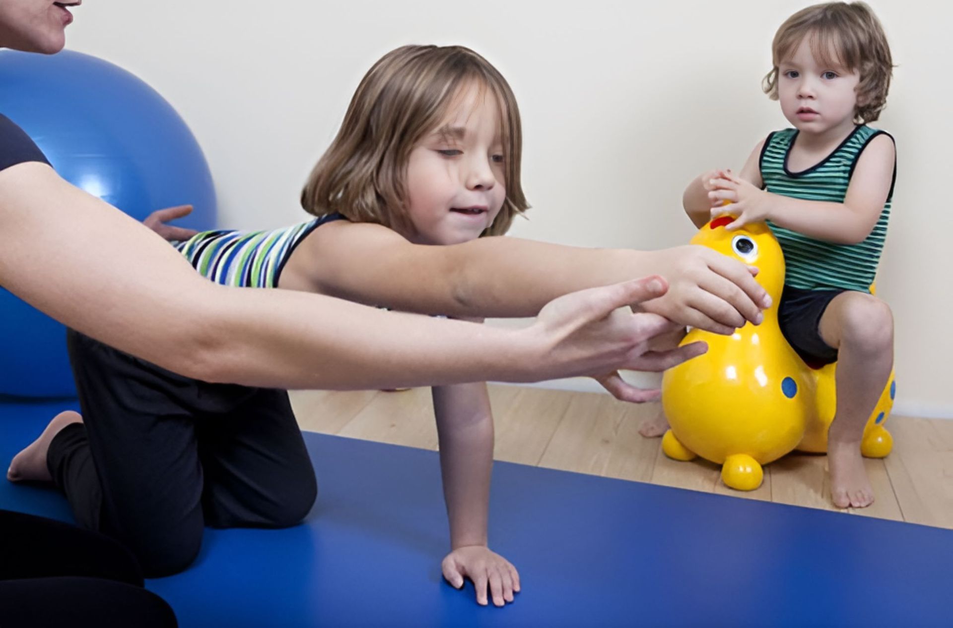 A Little Girl is Playing With a Yellow Toy — Newcastle Paediatric Occupational Therapy in Floraville, NSW