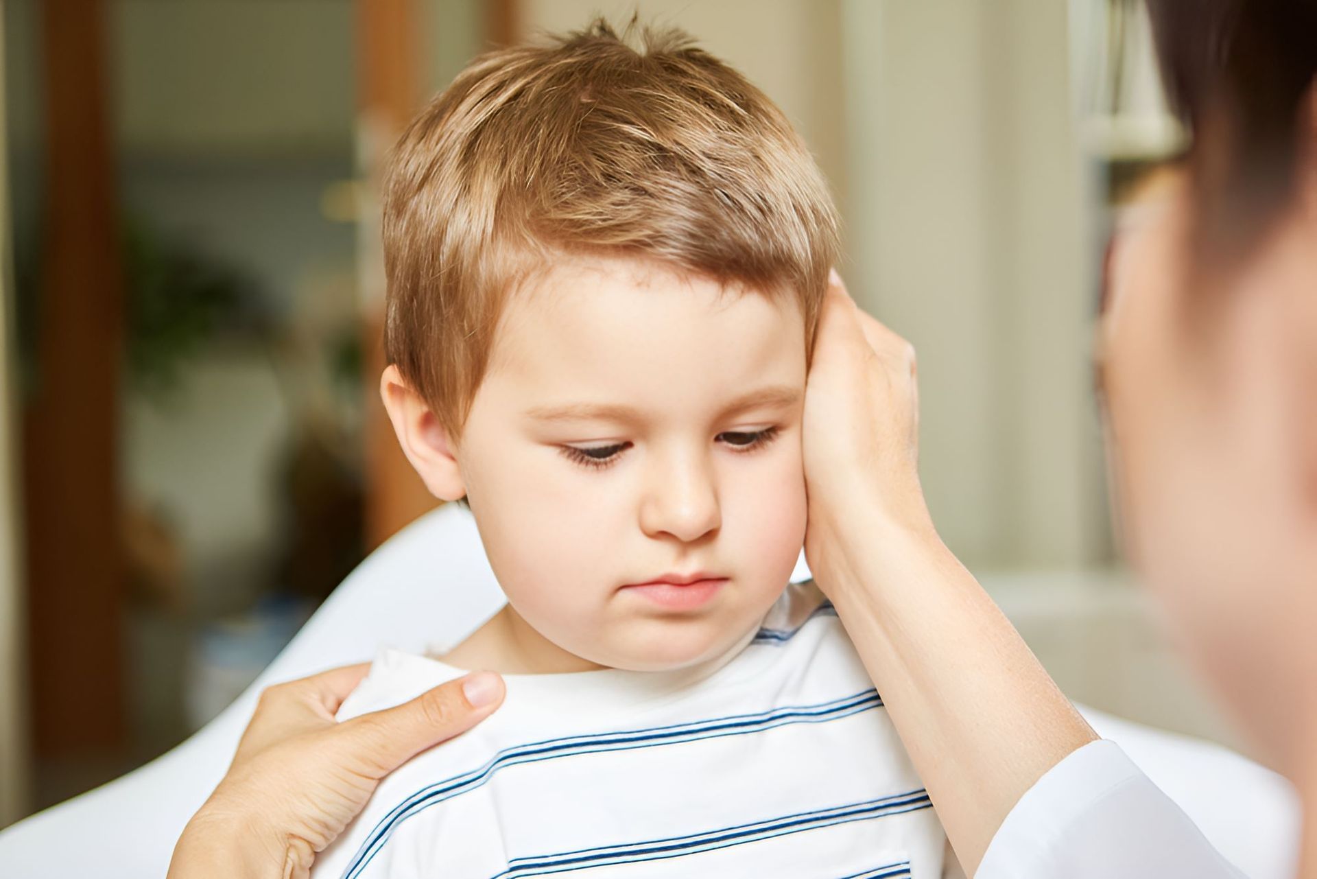 A Woman is Holding a Little Boy in Her Arms — Newcastle Paediatric Occupational Therapy in Swansea, NSW
