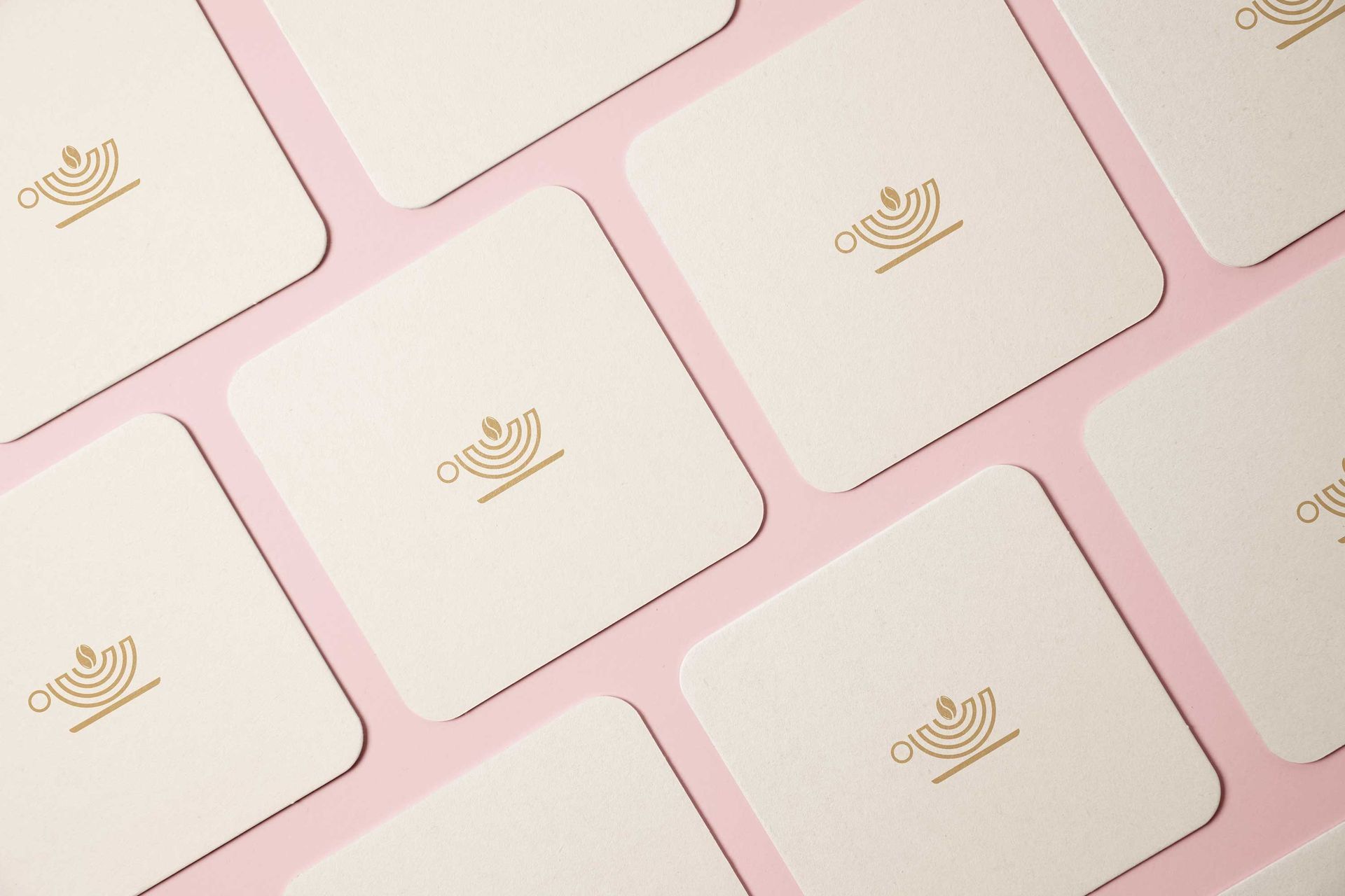 A group of coasters are sitting on top of each other on a pink surface.