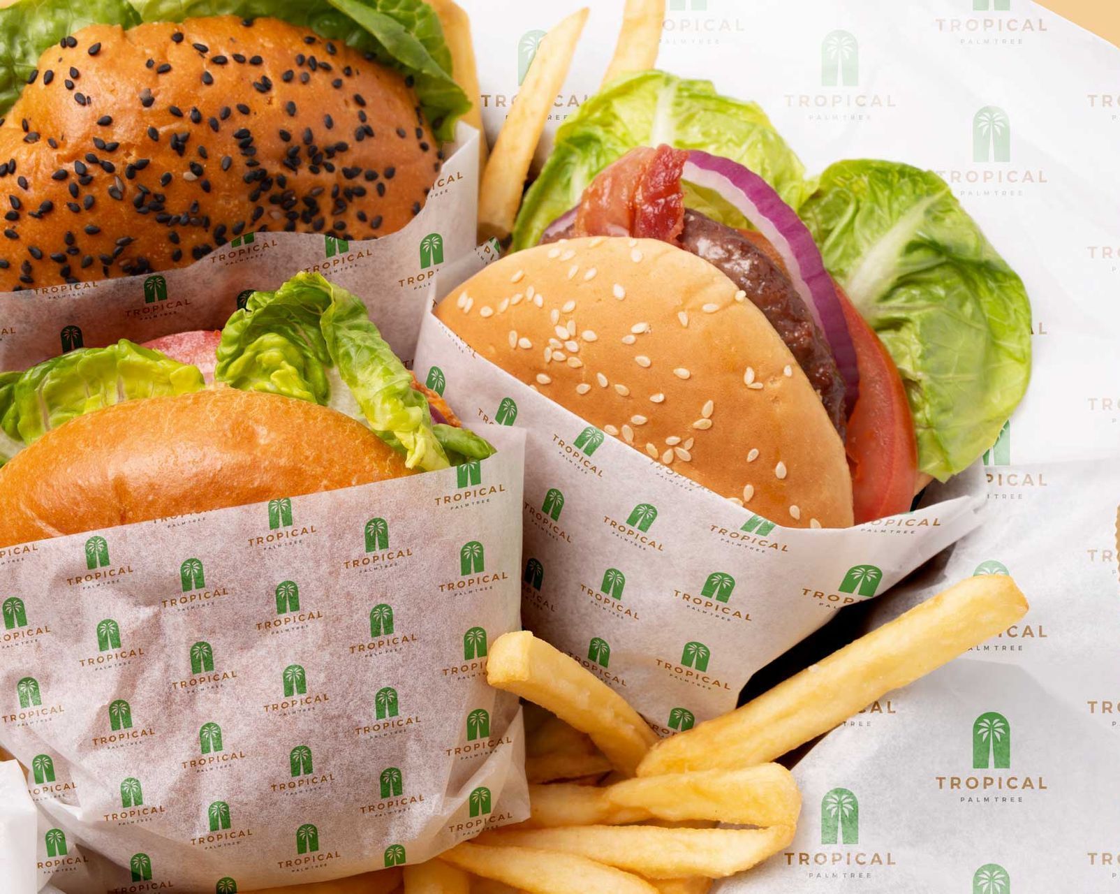 Two hamburgers and french fries wrapped in tropical paper