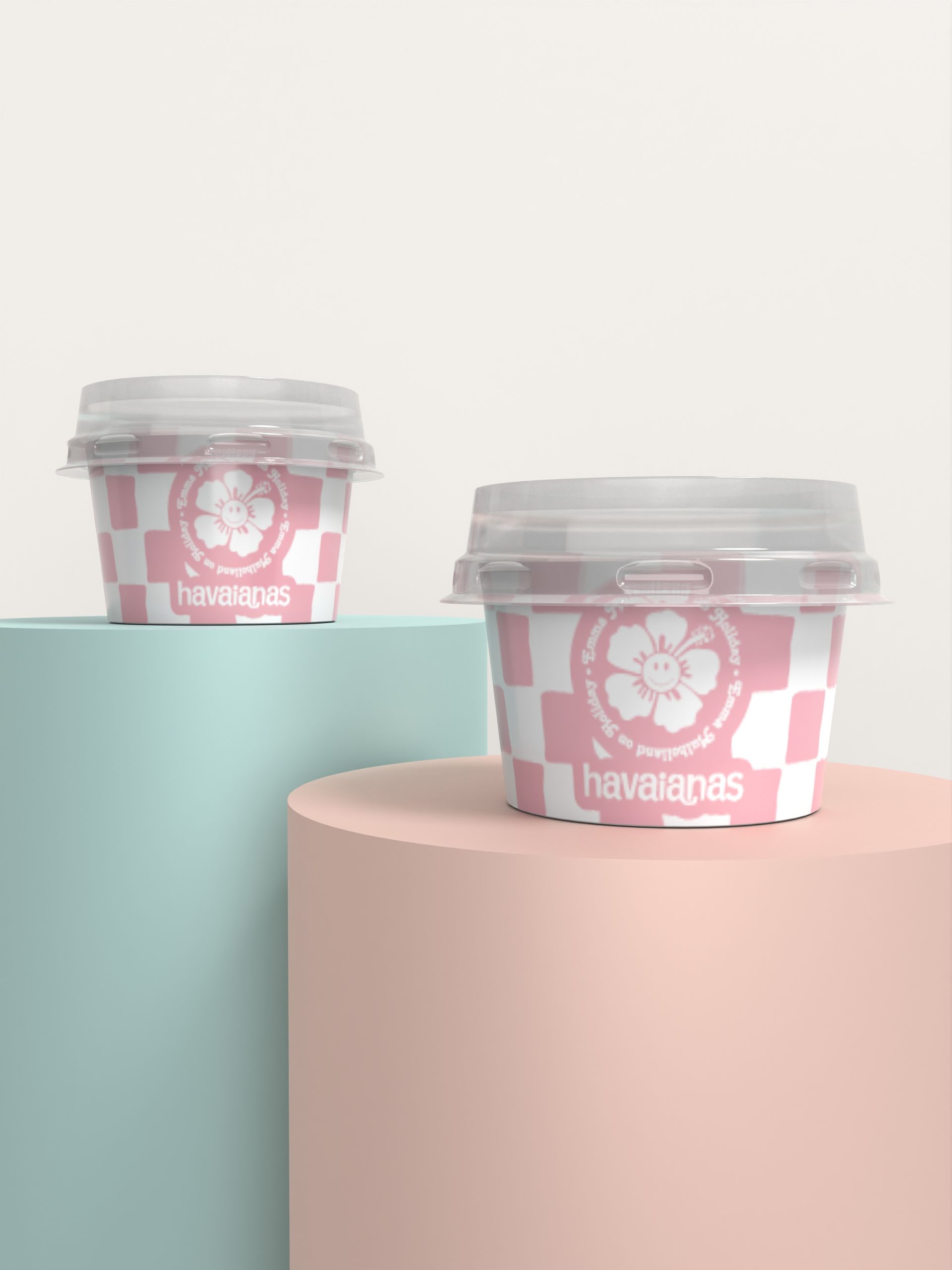 Two cups of ice cream are sitting on top of a pink cylinder.