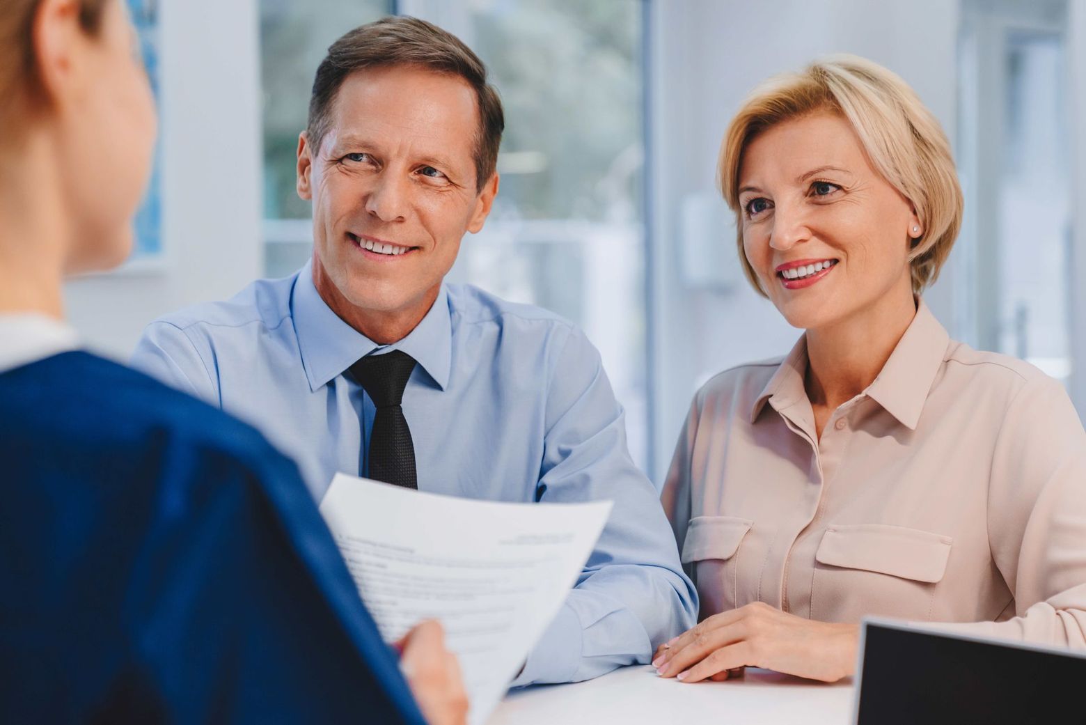 a man and woman are sitting at a table talking to a doctor