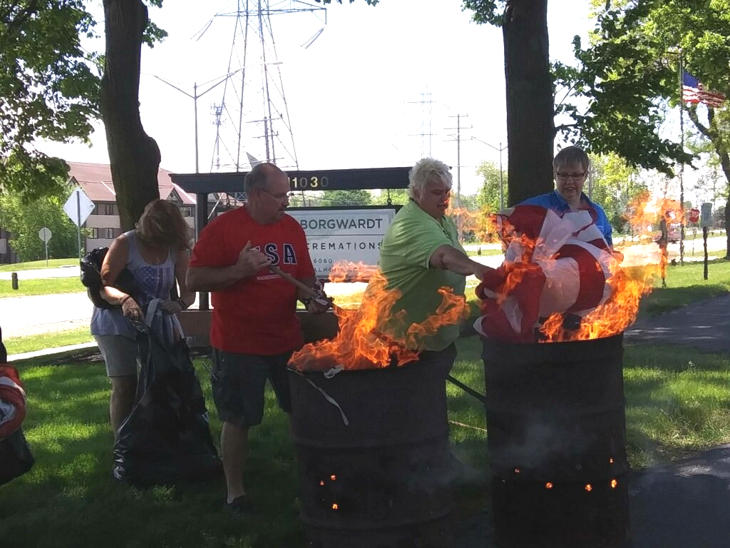 Volunteers set fire to warn American flags at Schramka-Borgwardt Funeral Home