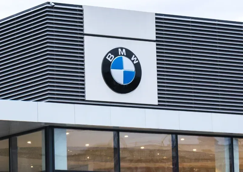 BMW dealership sign on a modern building with black and white exterior panels.