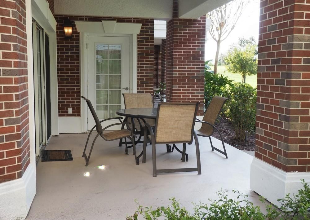 A patio with a table and chairs in front of a brick building