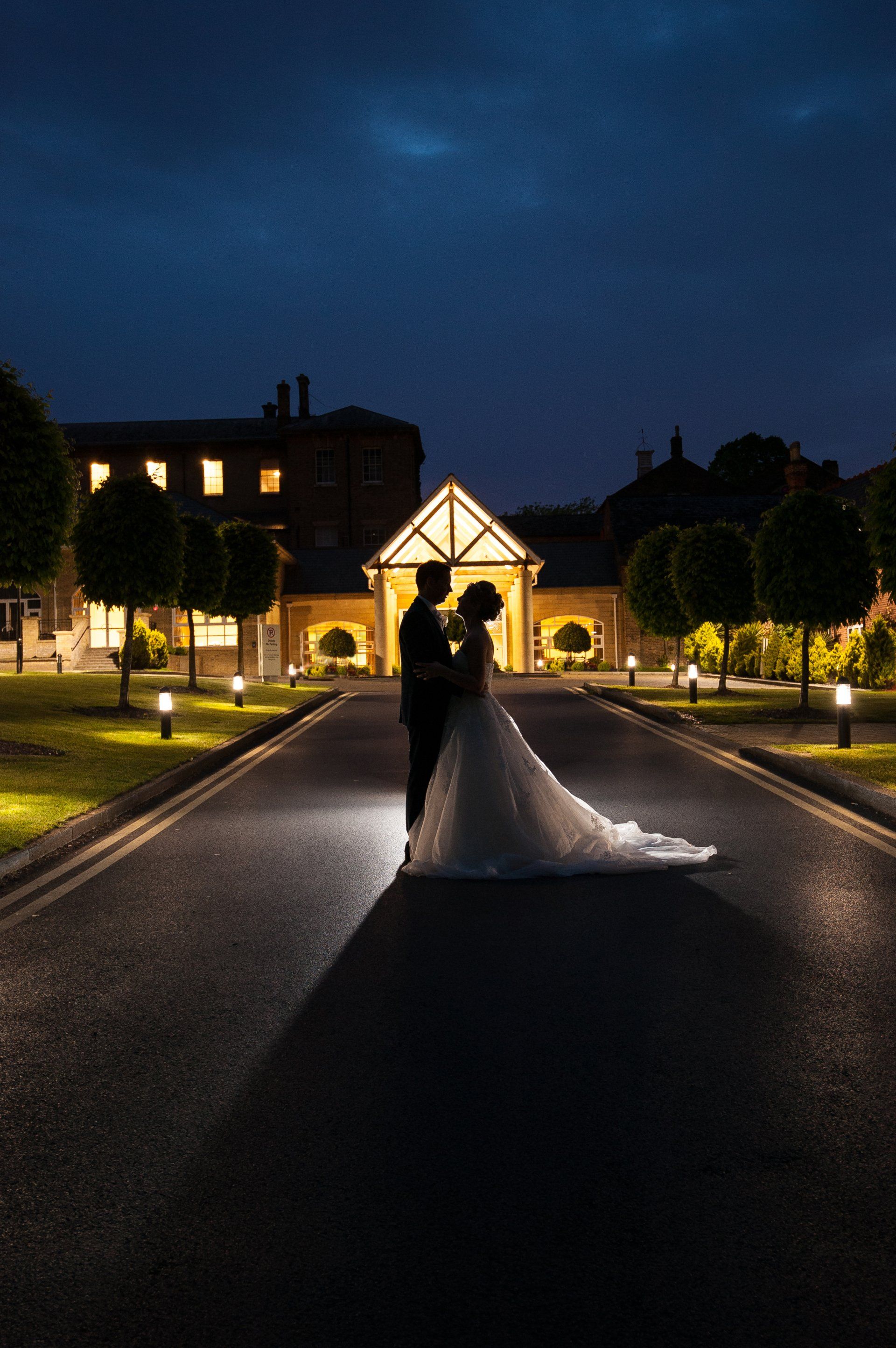 Bride and Groom kissing on a moonlit night at the entrance to Beaumont Estate Hotel
