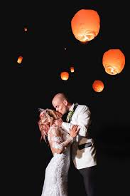 Bride and Groom kiss at night as lanterns float in the night sky