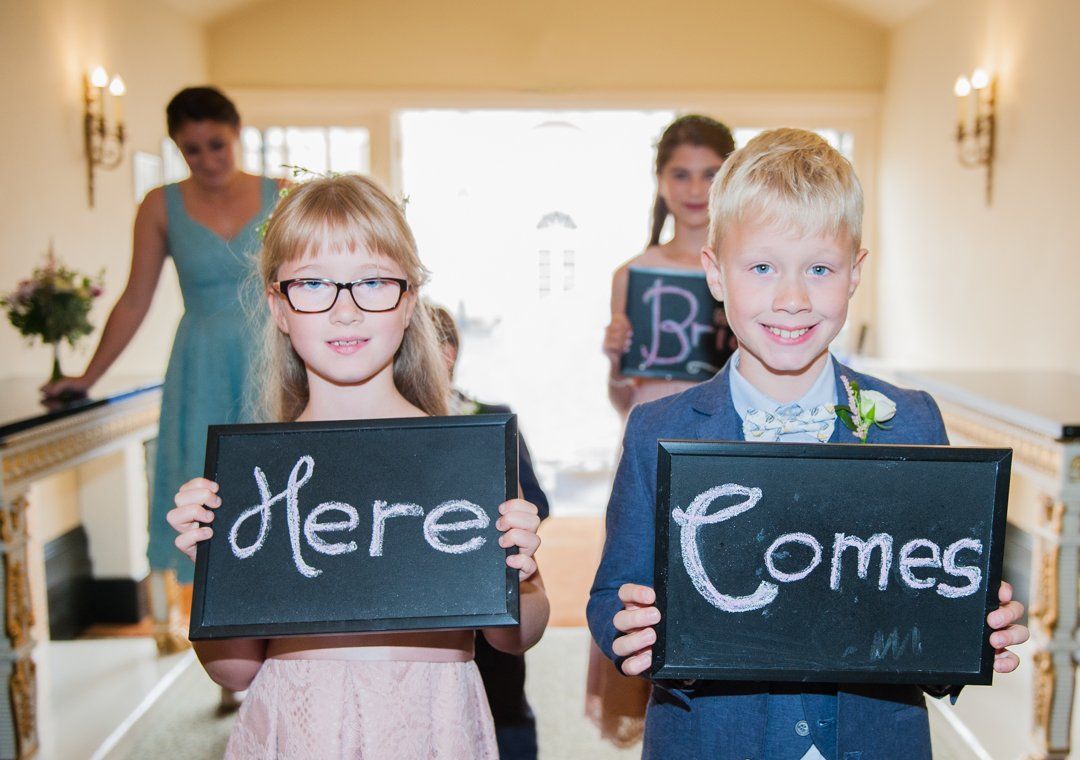 Bridesmaids and Pageboys holding small black chalkboards, 