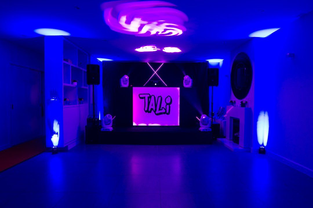 Room shot of Maxime Events DJ Station, with purple spotlights and sign with Tali's name just before her Batmitzvah party