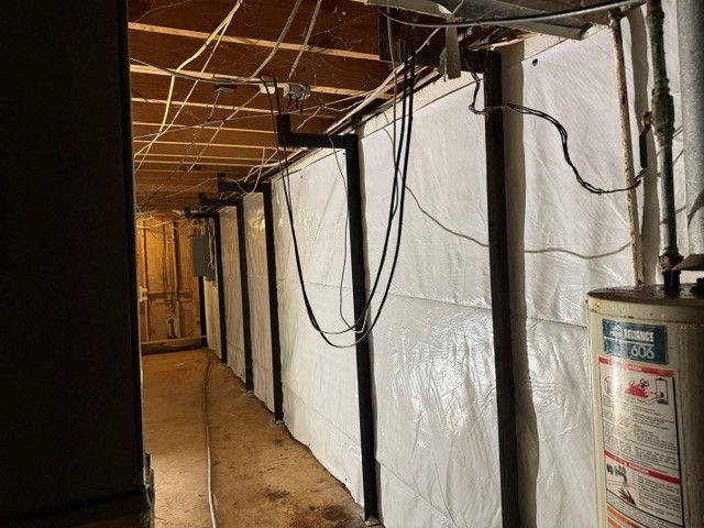 Man standing on cracked concrete patio, beside house with siding.