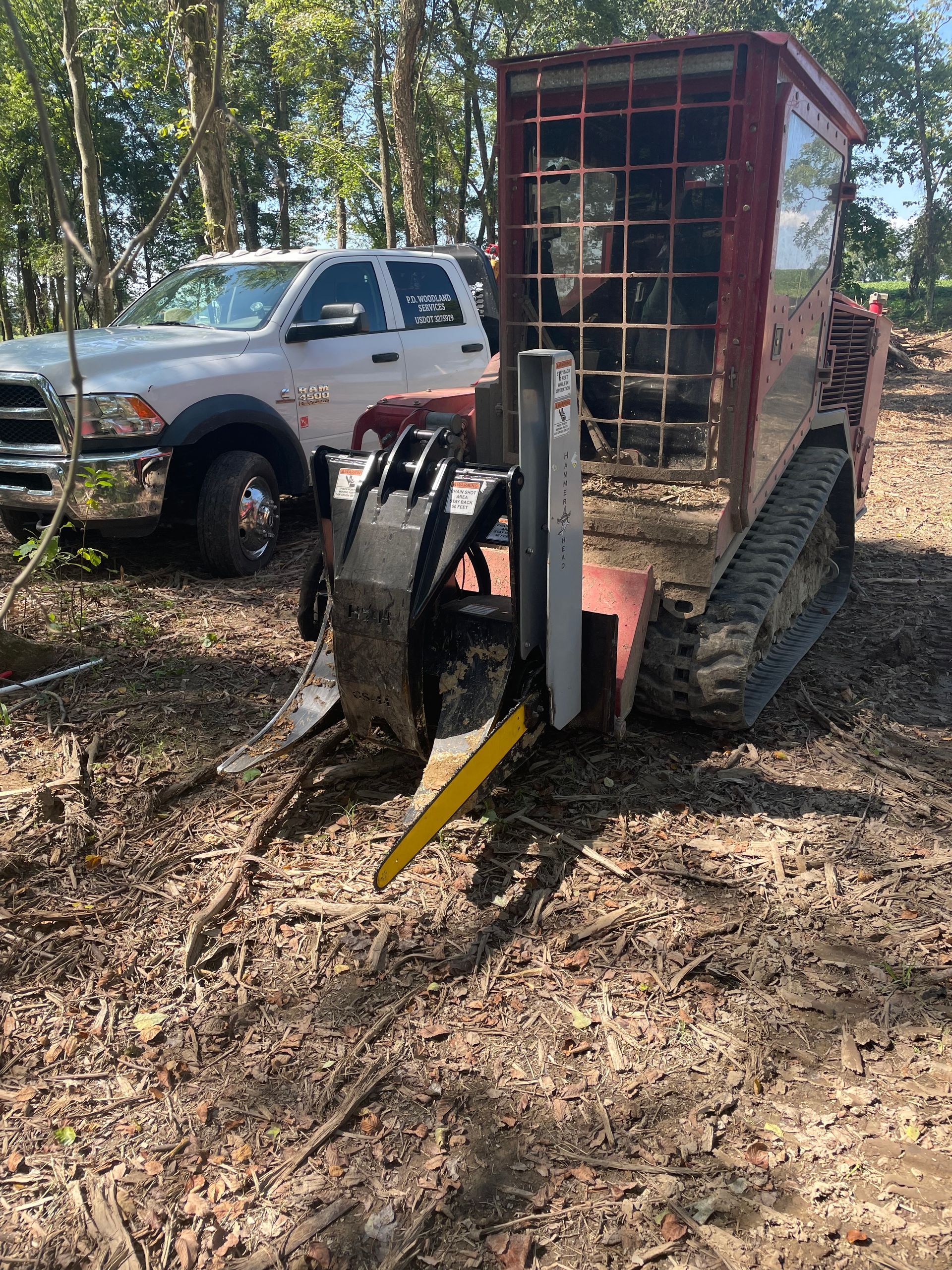 A bulldozer is parked in the dirt next to a truck.
