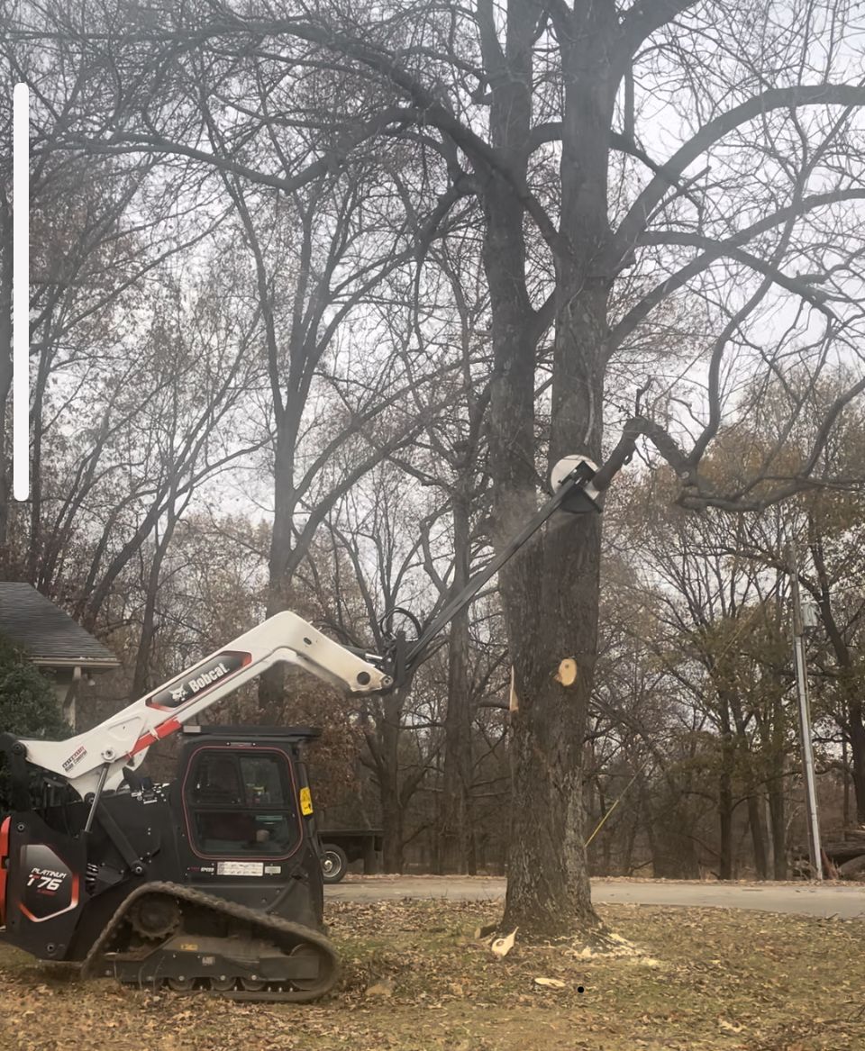 A snow blower is parked in a grassy field next to a sign.