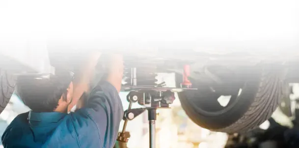 Technician performing maintenance below vehicle | Jimmy's Auto Outlet