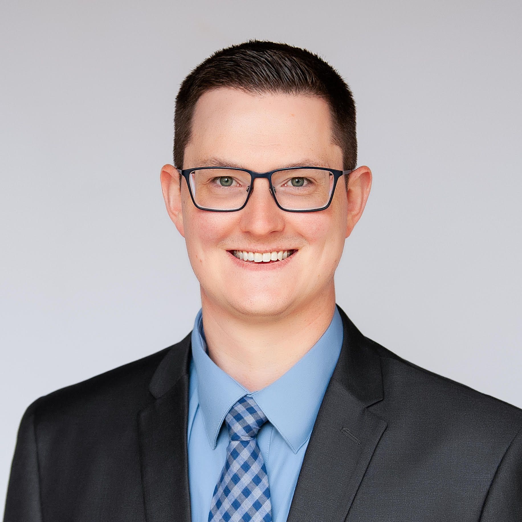 A man in a suit and tie is smiling for the camera.