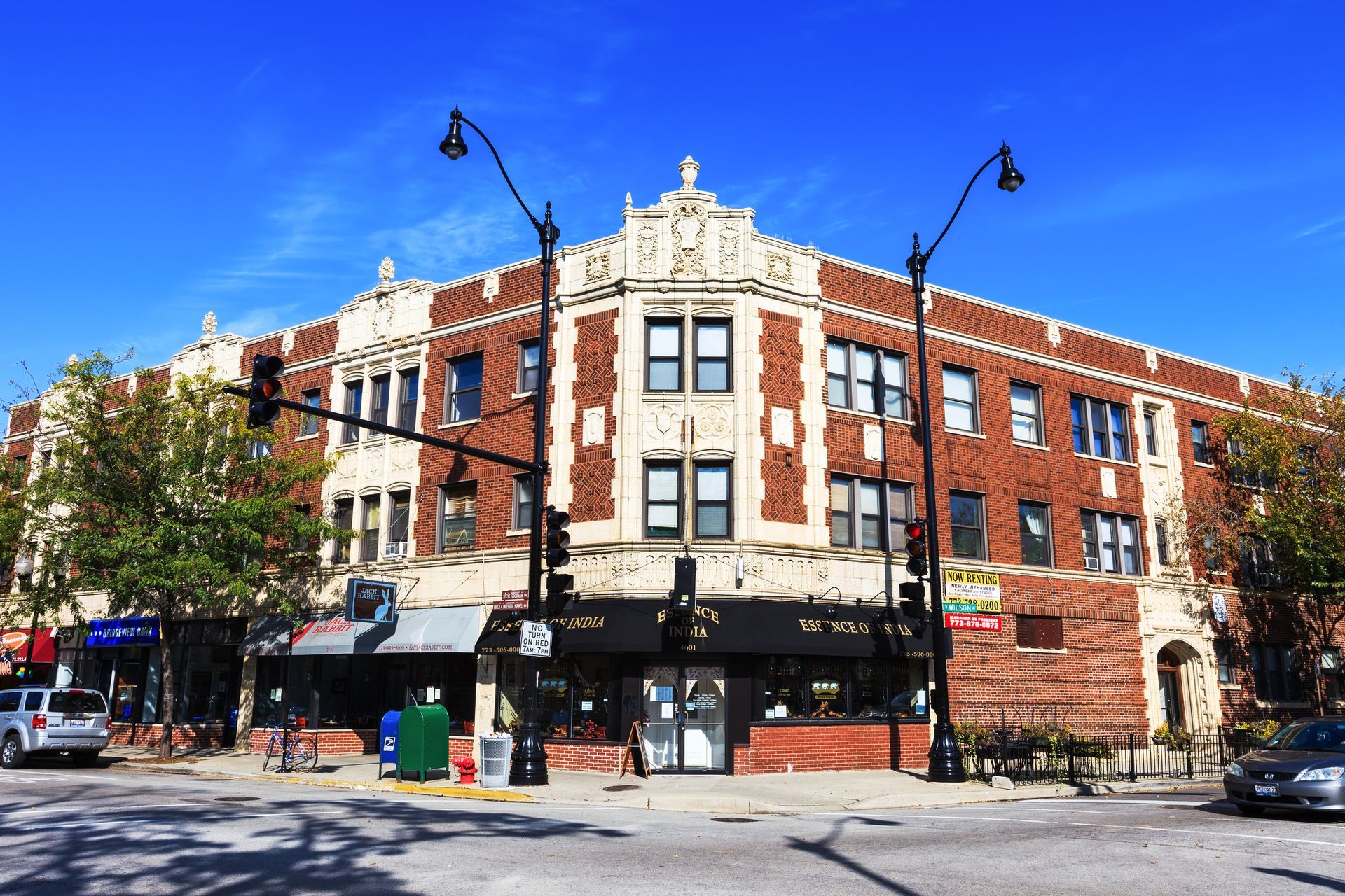 A large brick building is sitting on the corner of a city street.