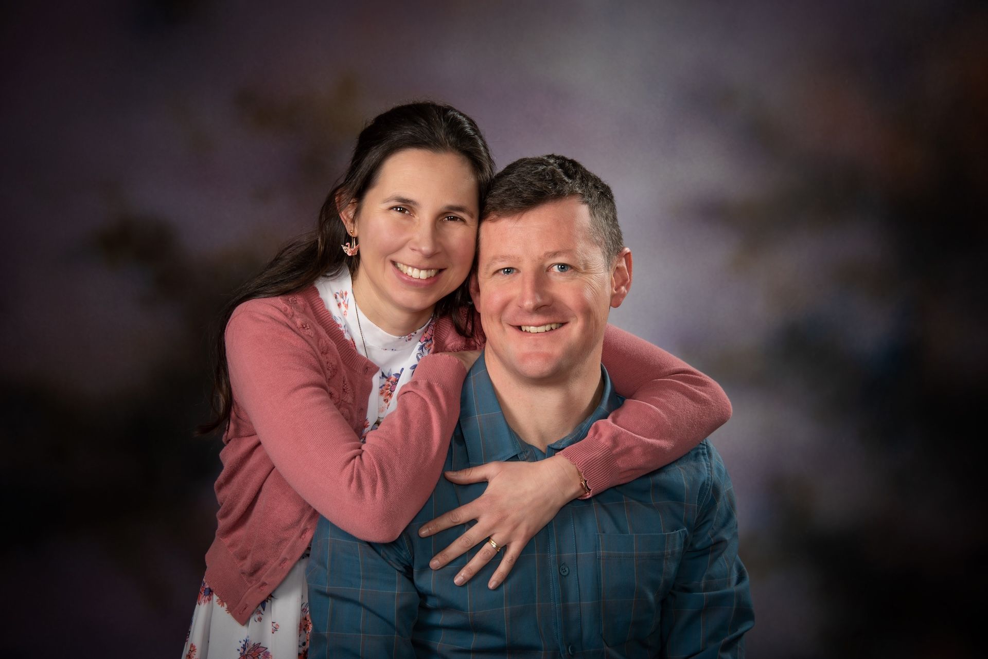 A Woman in a Black Dress is Smiling in Front of a Purple Background — Dale Wright Portrait Maker in Yarrawonga, VIC