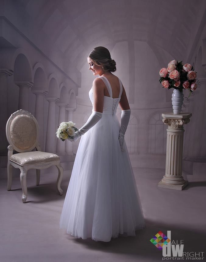 A Woman in a White Dress and Gloves is Standing Holding a Bouquet of Flowers — Dale Wright Portrait Maker in Shepparton, VIC