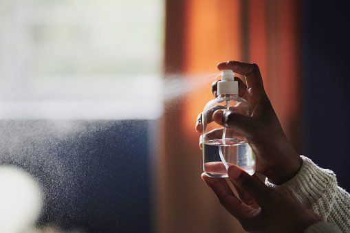 Person using a spray bottle to eliminate odors.