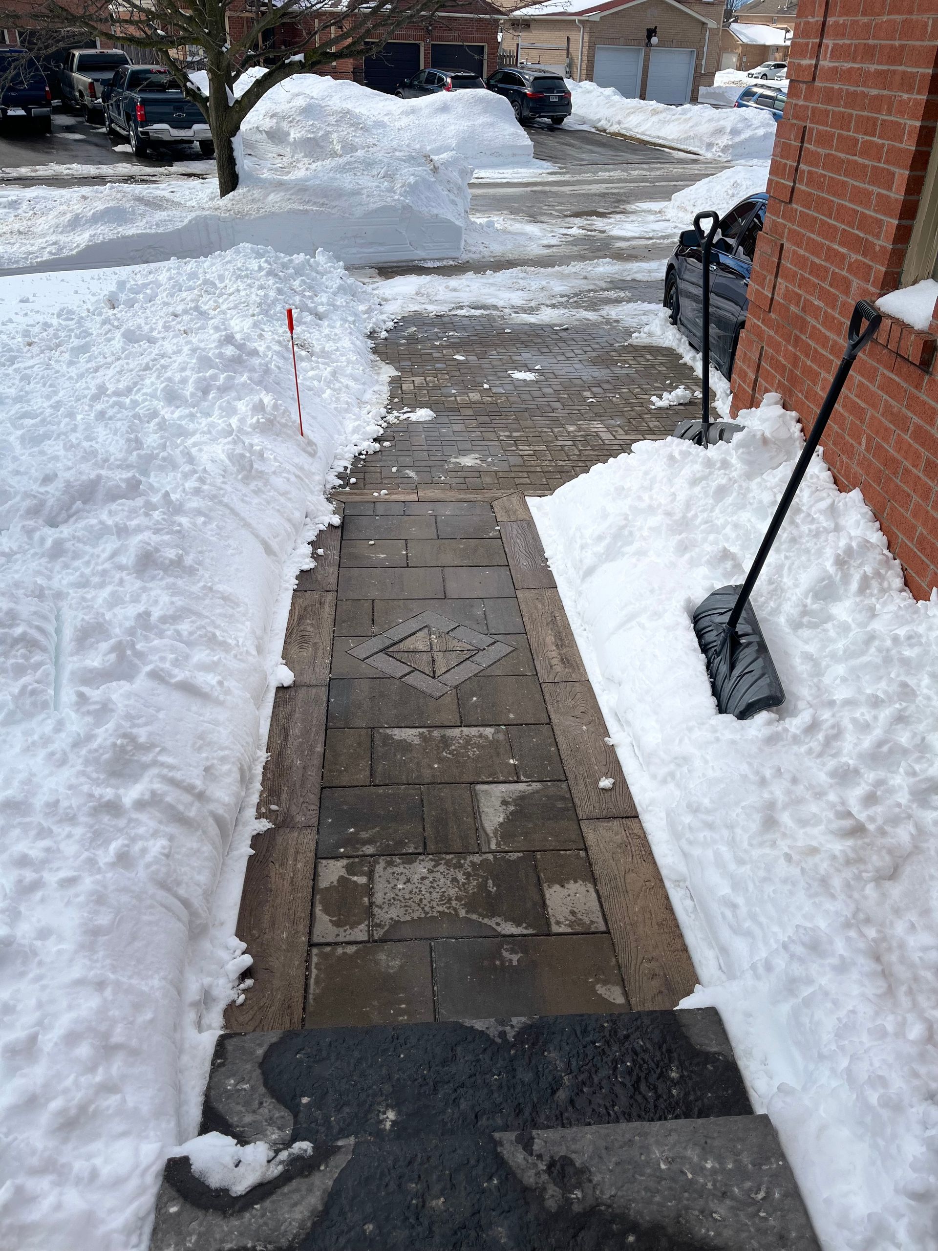 a snow shovel is on the sidewalk next to a brick building