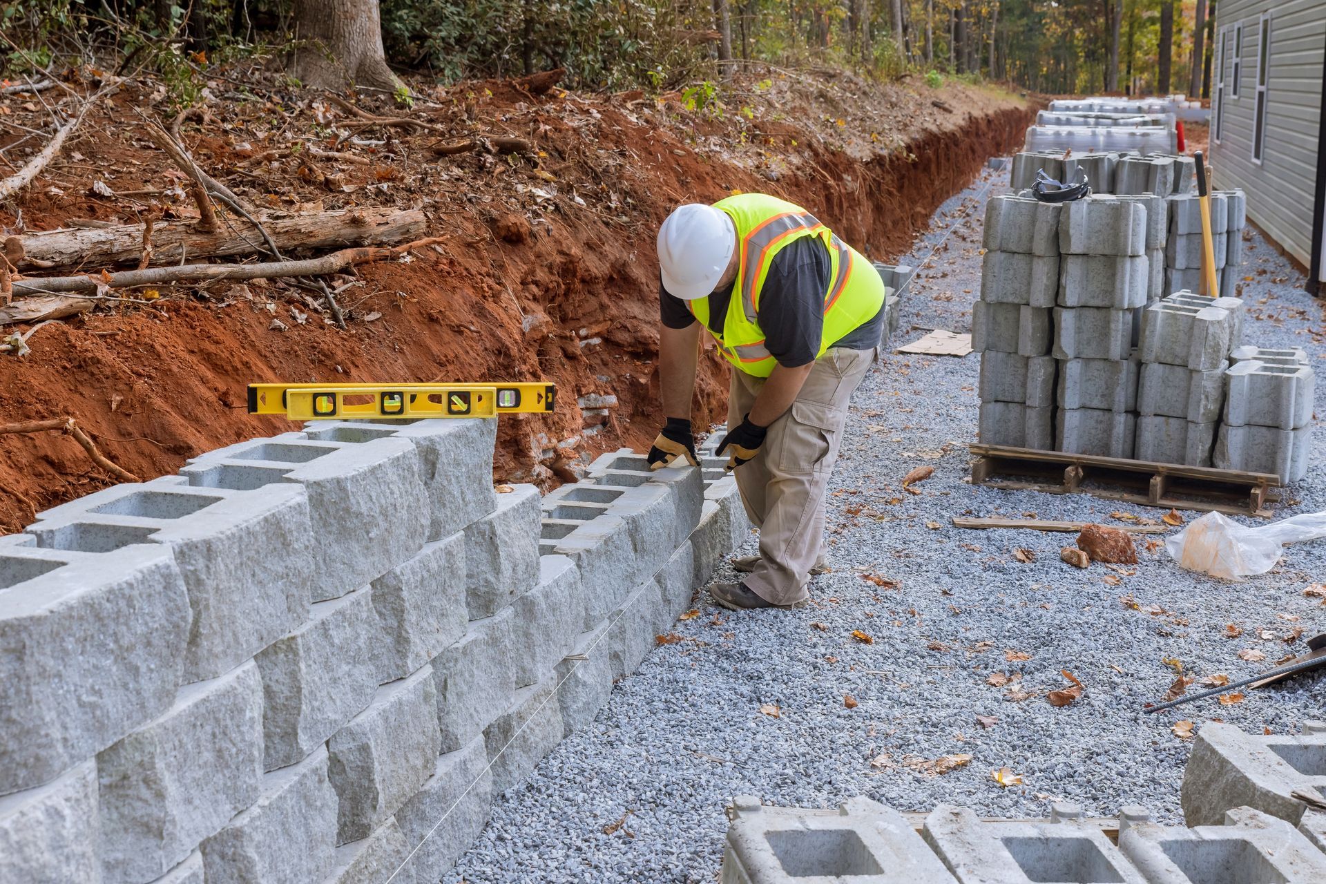 a construction worker is building a concrete wall .