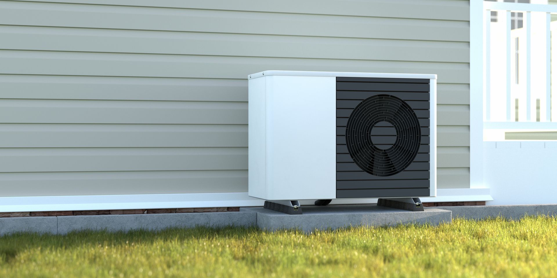 A white air conditioner is sitting on the side of a house.
