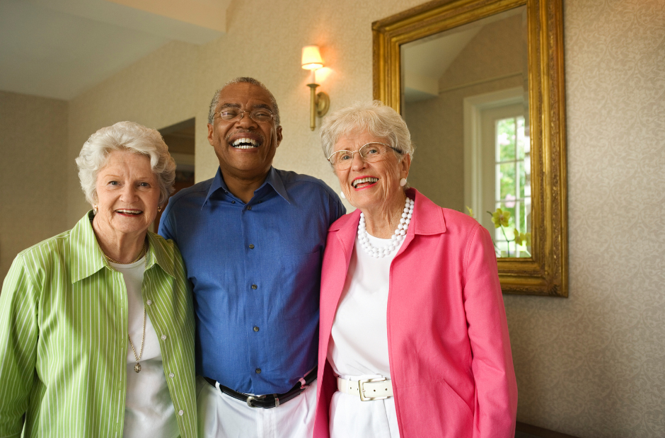 A man and two women are posing for a picture in front of a mirror.