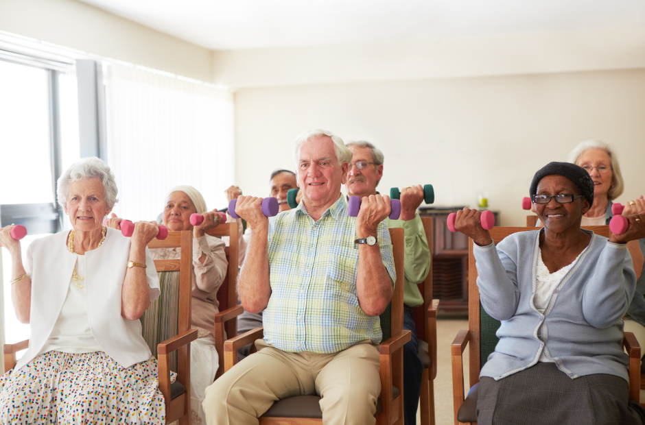 A group of elderly people are sitting in chairs holding dumbbells.