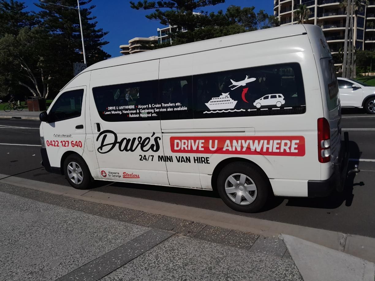 White Van Labelled Dave's Drive U Anywhere Parked Near a Sidewalk — Dave's Drive U Anywhere 24/7 Mini Van Hire In Kiama, NSW