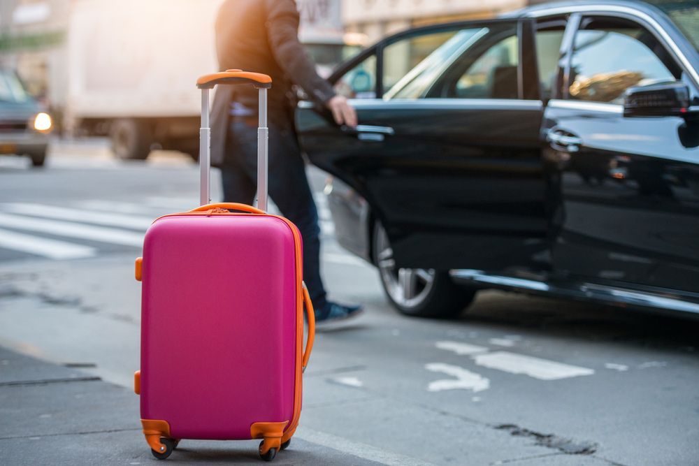 Pink Suitcase on City Street — Dave's Drive U Anywhere 24/7 Mini Van Hire In Shellharbour, NSW