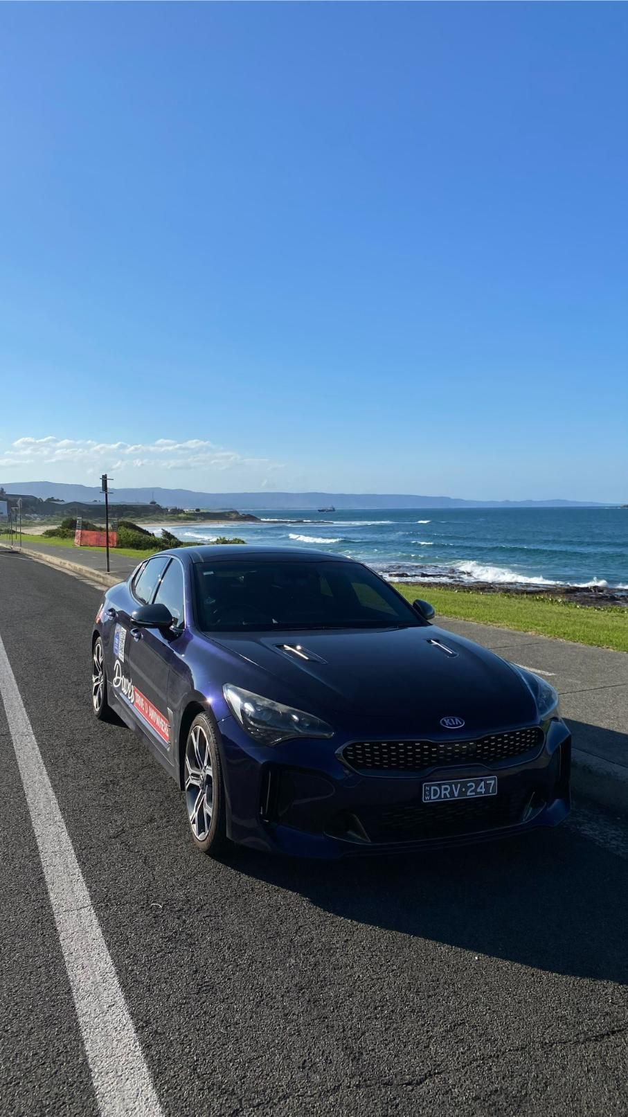 Dark Blue Kia Stinger Parked by a Road — Dave's Drive U Anywhere 24/7 Mini Van Hire In Dapto, NSW