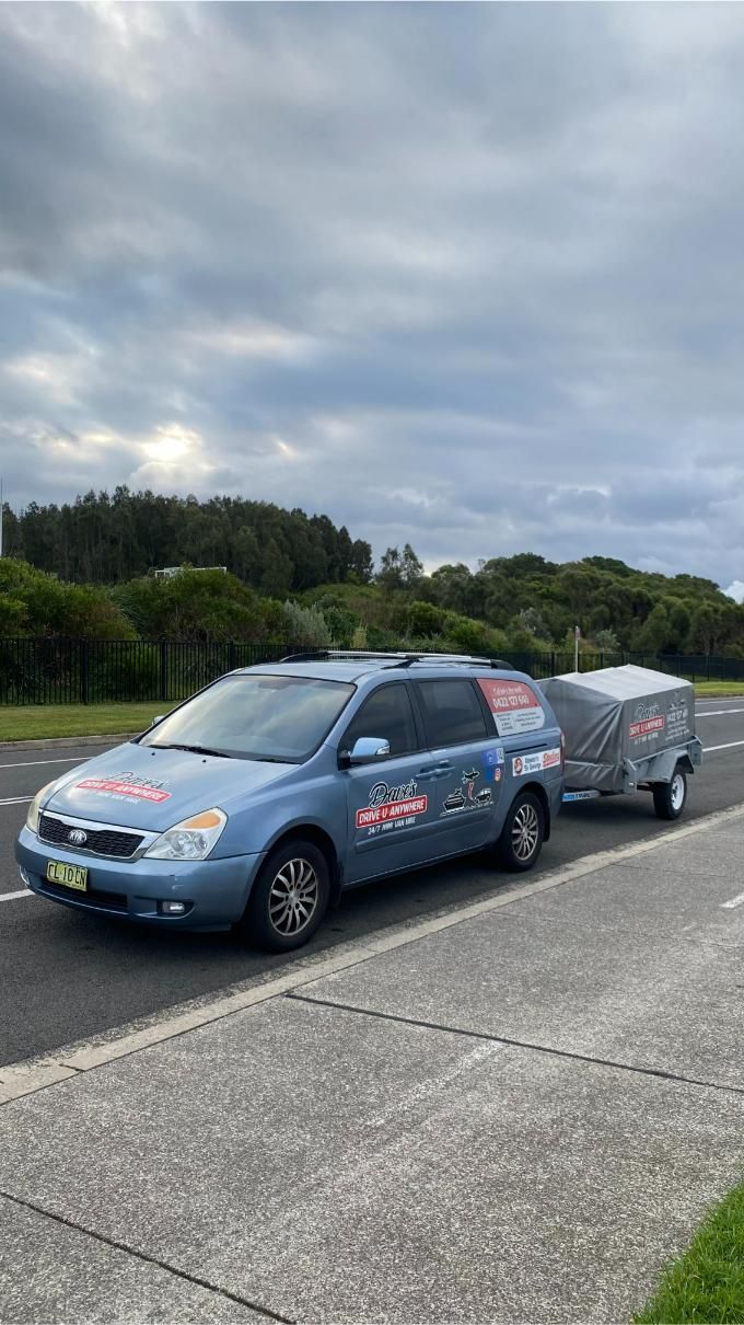 Blue Minivan Towing a Trailer on a Road — Dave's Drive U Anywhere 24/7 Mini Van Hire In Dapto, NSW