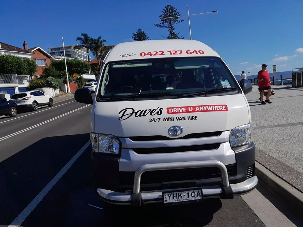 A White Van Is Parked on The Side of The Road — Dave's Drive U Anywhere 24/7 Mini Van Hire In Shellharbour, NSW