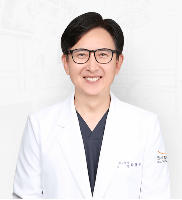 Smiling man in glasses and white lab coat, possibly a doctor, against a white backdrop.