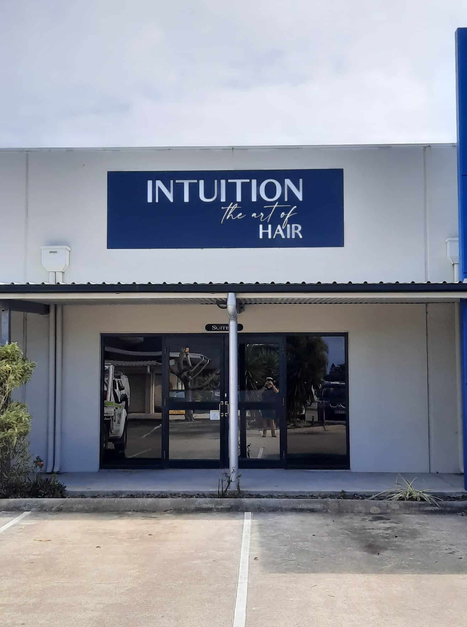 A White Building With A Blue Sign That Says Intuition — Sun City Signs In Paget, QLD