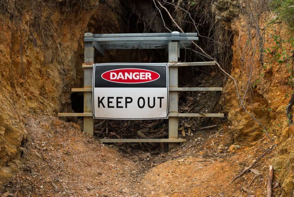 A Danger Keep Out Sign Is Hanging On A Wooden Fence — Sun City Signs In Paget, QLD