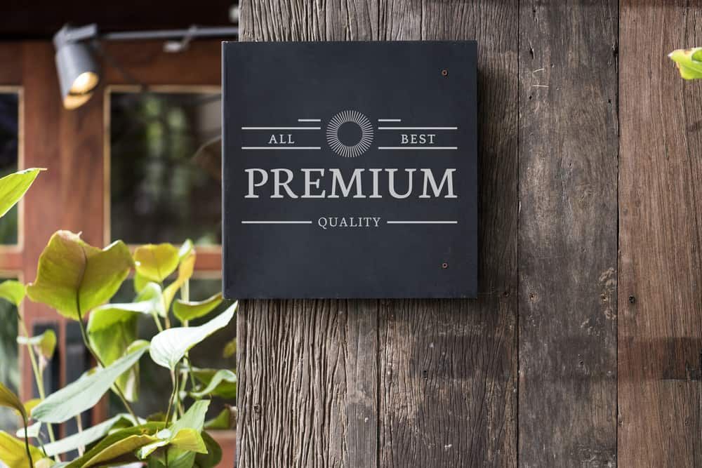 An image of a clean sign on a wooden fence that reads 'premium quality'.