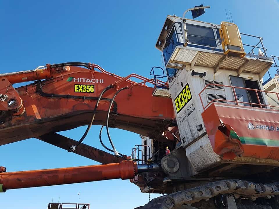 A Hitachi Excavator Is Parked In Front Of A Blue Sky — Sun City Signs In Dysart, QLD