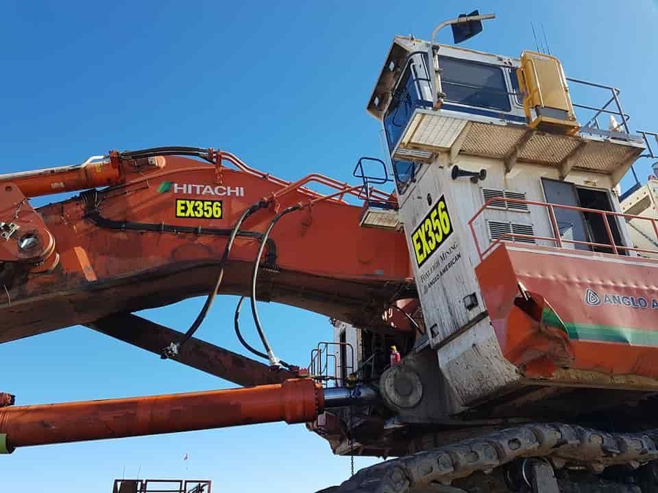 A Hitachi Excavator Is Sitting On The Ground With A Blue Sky In The Background — Sun City Signs In Paget, QLD