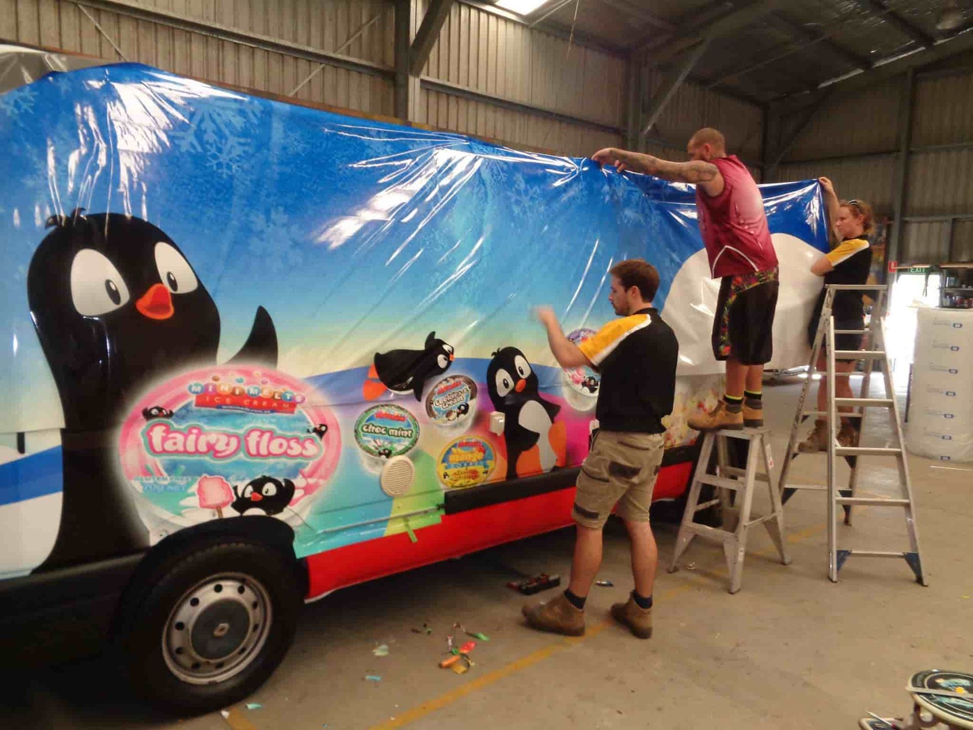A Group Of Men Are Wrapping A Fairy Flex Truck — Sun City Signs In Dysart, QLD