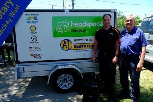 Two Men Standing In Front Of A Trailer That Says Headspace On It — Sun City Signs In Dysart, QLD