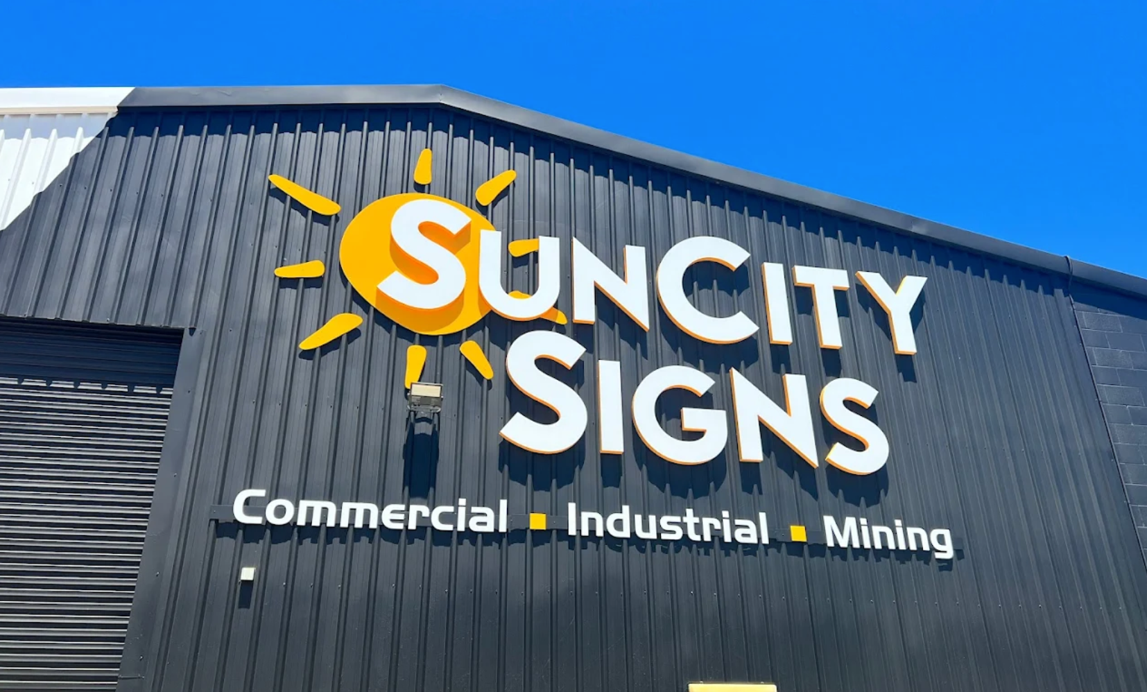Suncity Signs storefront: sign with a sun graphic and text, 