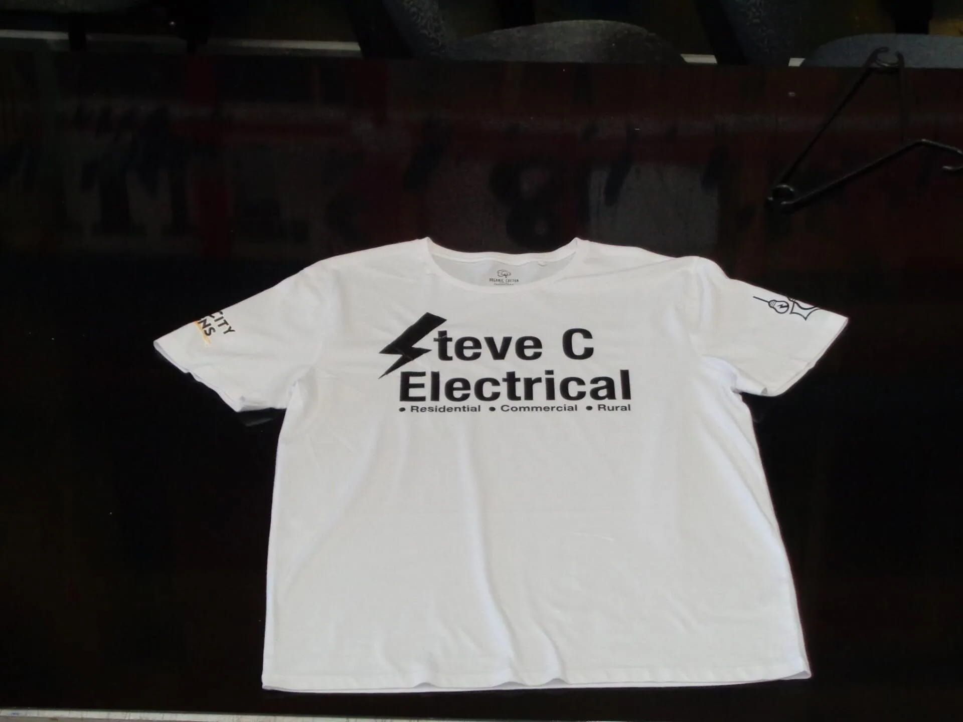 A White T-shirt That Says Steve C Electrical On It — Sun City Signs In Paget, QLD