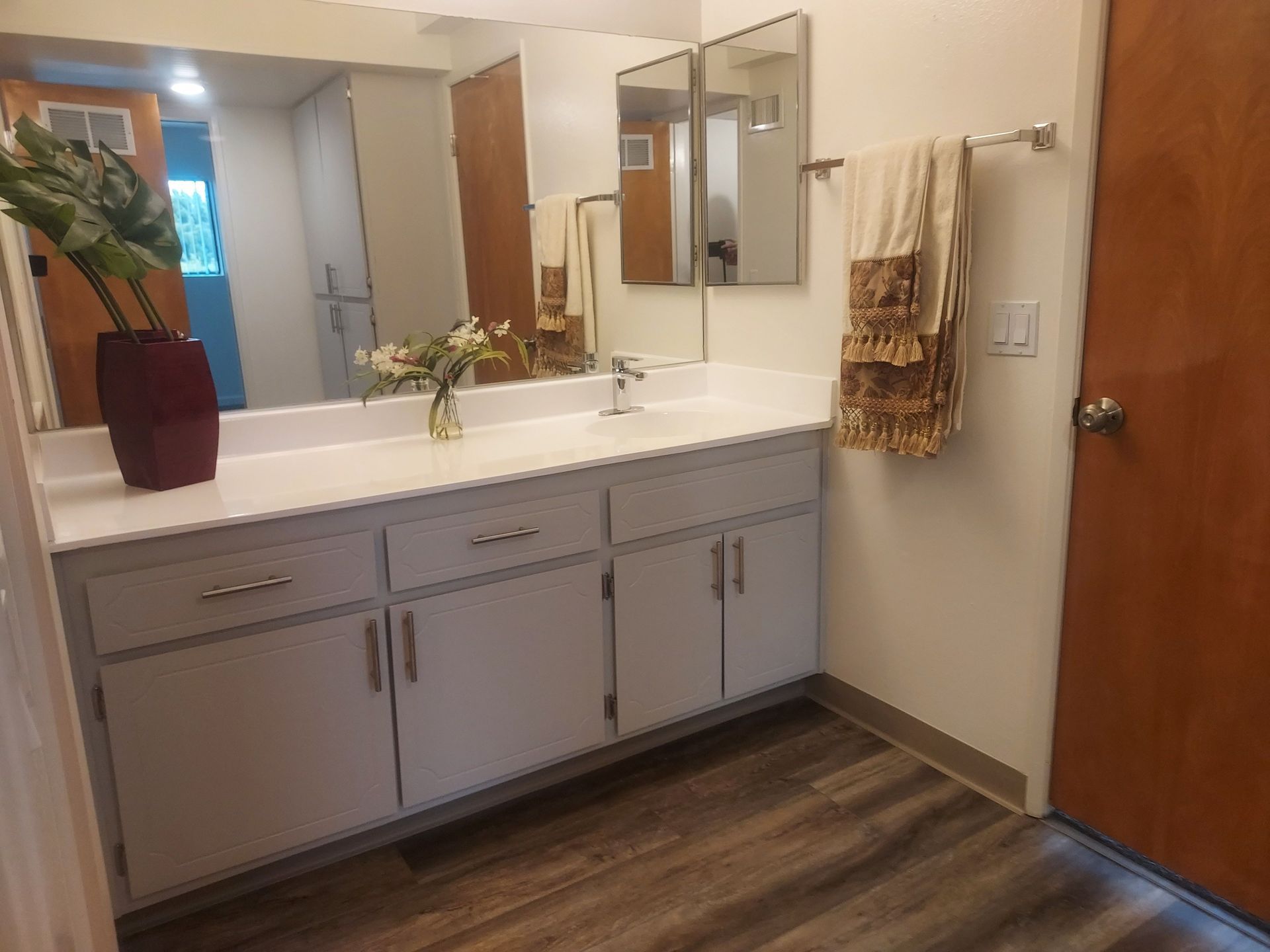 A bathroom with a sink and two mirrors