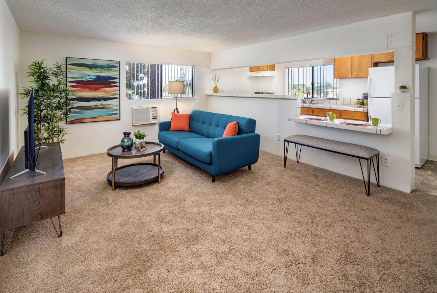 A living room with a blue couch , coffee table , and television.