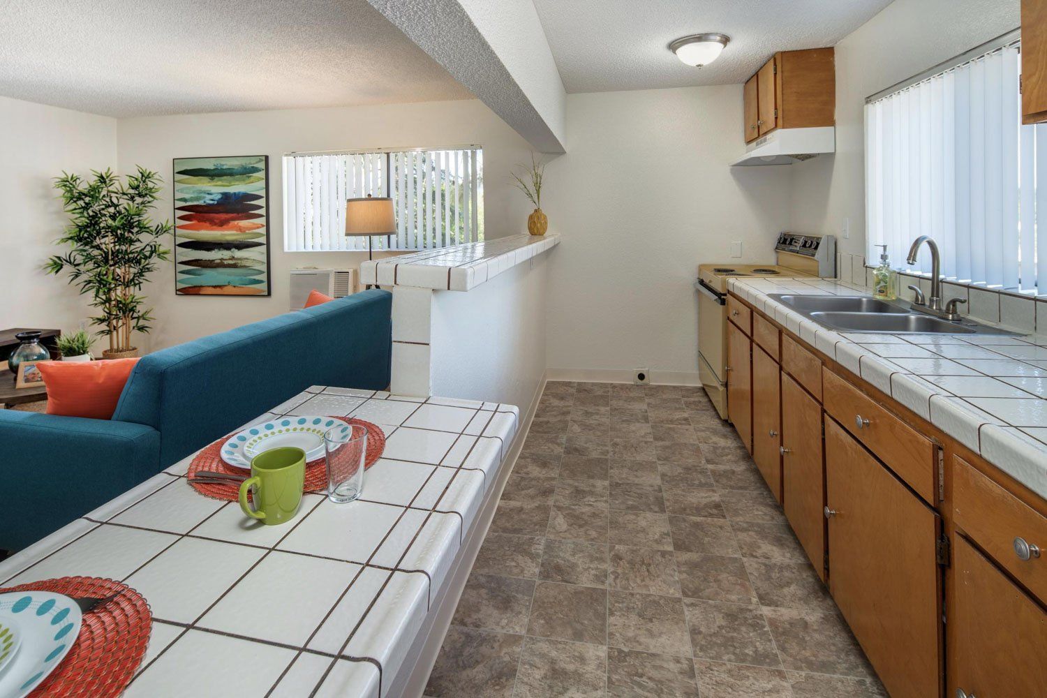 A kitchen with a table and a couch in the background